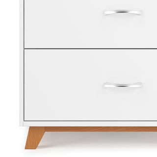 A close-up of the Child Craft Soho 3-Drawer Dresser in White/Natural, featuring two visible drawers with silver handles and natural wooden legs.