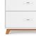 A close-up of the Child Craft Soho 3-Drawer Dresser in White/Natural, featuring two visible drawers with silver handles and natural wooden legs.