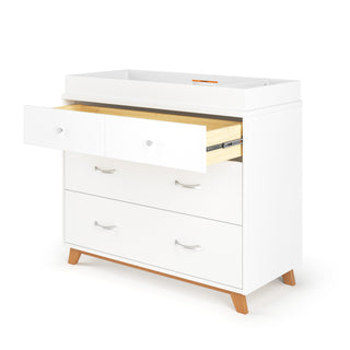 The Child Craft Soho 3-Drawer Dresser in White/Natural features three drawers (one shown open with a light wood interior), angled wooden legs, and a raised flat top surface ideal for use as a changing table.
