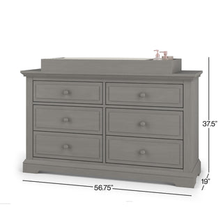 The Child Craft F01792 Universal Changing Table Topper in Lunar Gray sits atop a six-drawer dresser (56.75"W x 37.5"H x 19"D), creating a convenient changing space.