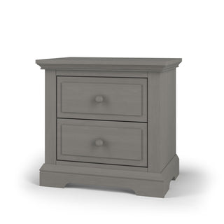 The Child Craft Jordyn Nightstand in Lunar Gray features baby-safe finishes, two drawers with round knobs, and a classic design with crown molding and a subtly curved base. Ready to assemble.