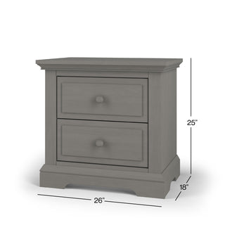The Child Craft Jordyn Nightstand, Ready-to-Assemble in Lunar Gray, features crown molding, two drawers with round knobs, baby-safe finishes, and measures 25"H x 26"W x 18"D.