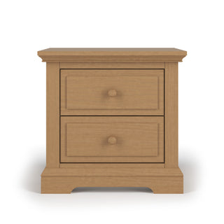 The Child Craft Jordyn Nightstand in Biscotti is a ready-to-assemble wooden nursery nightstand with two drawers, round knobs, and classic crown molding details, shown against a plain white background.