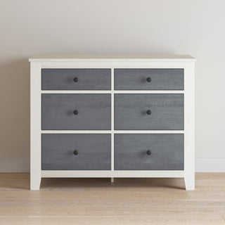 The Child Craft Ocean Grove Double Dresser in White/Gray features six drawers with dark gray fronts and round black knobs, bringing nautical farmhouse charm to your nursery.