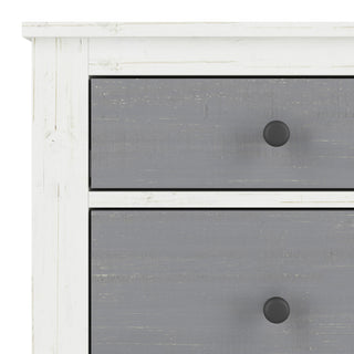 Close-up of the Ocean Grove Double Dresser by Child Craft in White/Gray, showing the distressed white frame, gray drawers with round black knobs—ideal nautical farmhouse style nursery furniture.