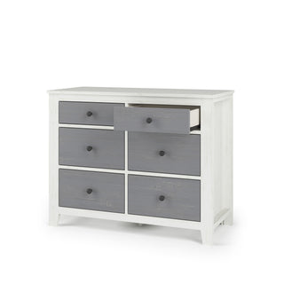 The Child Craft Ocean Grove Double Dresser in White/Gray is a wooden nursery piece with six gray drawers, each with a round black knob and short legs that create nautical farmhouse charm. One drawer is shown partially open.