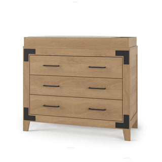 The Child Craft F01792 Universal Changing Table Topper in Nutmeg pairs perfectly with a wooden dresser featuring three drawers, black metal brackets and handles, and four short legs for versatile nursery use.