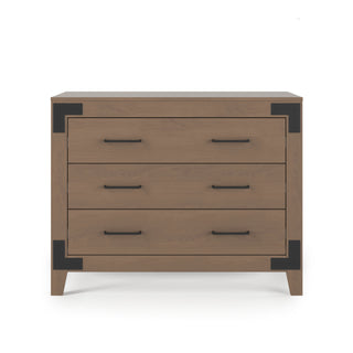 The Child Craft Lucas Dresser in Dusty Heather features three wooden drawers with black metal corner brackets and handles, shown against a white background.