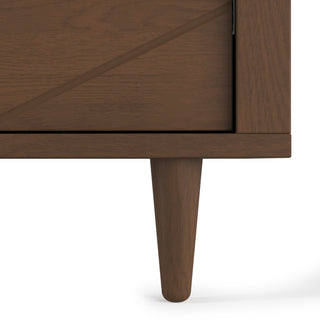 Close-up of the Surrey Hill 3 Drawer Dresser by Child Craft in Toasted Chestnut, showing its tapered legs and diagonal groove design against a white background.