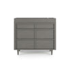 The Child Craft F01792 Universal Changing Table Topper in Lunar Gray is displayed on a modern dresser with three drawers, angled legs, and a raised top edge—ideal for nursery use—all shown against a plain white background.