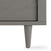 Close-up of the bottom corner of the Child Craft Surrey Hill 3 Drawer Dresser in Lunar Gray, showing its single tapered leg and door with subtle diagonal design—an ideal, stylish addition to any nursery.