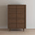 The Child Craft Surrey Hill 5 Drawer Chest in Toasted Chestnut features mid-century modern style with angled legs and geometric drawer fronts, shown against a white wall and light wood floor.