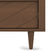 Close-up of the Surrey Hill 5 Drawer Chest by Child Craft in toasted chestnut, showing a medium brown finish, diagonal groove pattern on the door, and an angled, tapered leg.