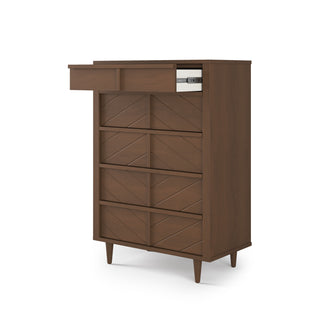 The Child Craft Surrey Hill 5 Drawer Chest in Toasted Chestnut features a geometric-patterned front, angled legs, and a partially open top drawer revealing books.