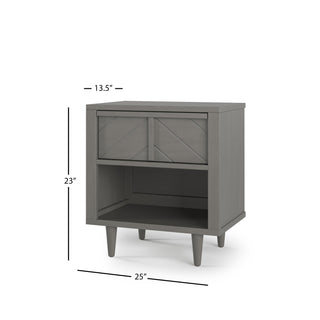 The Child Craft Surrey Hill Nightstand in Lunar Gray features angled legs, a drawer with a geometric pattern, an open lower shelf, and measures 25"W x 13.5"D x 23"H.