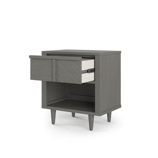 The Child Craft Surrey Hill Nightstand in Lunar Gray features angled legs, a partially open crisscross-pattern drawer, and an open lower shelf, shown against a white background.