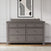 A gray double dresser with six drawers stands against a white paneled wall. A framed abstract art print hangs above, and a rectangular tray with small items sits atop the dresser—an elegant complement to the Child Craft Westgate 3-Piece Nursery Set with Crib, Dresser and Chest.