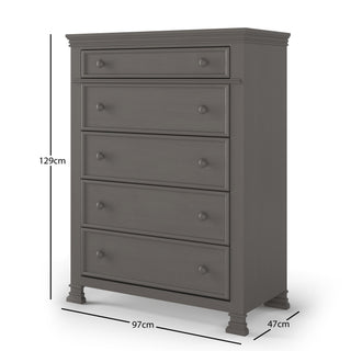 The Child Craft Westgate 5-Drawer Chest in Chelsea Gray is a tall wood dresser with decorative trim, five drawers, and four short legs. Dimensions: 129 cm high, 97 cm wide, 47 cm deep.