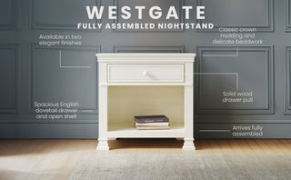 The Child Craft Westgate Nightstand in Vintage Linen is shown with a drawer and open shelf against a gray paneled wall. This nursery-ready piece features crown molding, a spacious drawer with solid wood pull, and arrives fully assembled.