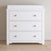The Child Craft Harmony 3-Drawer Dresser with Changing Table Topper in matte white features a modern design with clean lines and round silver handles, making it perfect for nursery storage or use as a changing station.