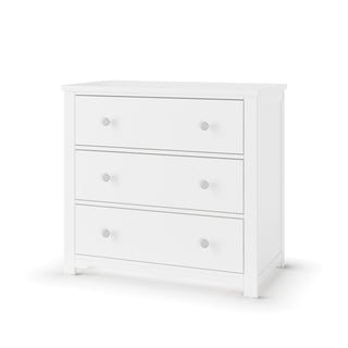 The Child Craft Harmony 3-Drawer Dresser with Changing Table Topper in matte white features a modern, simple design with round silver knobs—perfect nursery storage, shown standing on short legs against a plain white background.