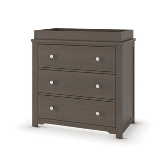 The Child Craft Harmony 3-Drawer Dresser with Changing Table Topper in Dapper Gray features three drawers, a raised edge topper, and short legs, shown against a white background.