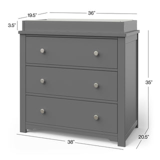 The Child Craft Harmony 3-Drawer Dresser with Changing Table Topper in Cool Gray features silver knobs and an attached topper. It measures 36"W (tray), 38"W (base), 35"H, 20.5"D; topper tray is 19.5" x 3.5". Ideal nursery furniture.
