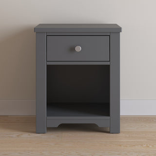 The Child Craft Harmony Nightstand in Cool Gray offers child-safe finishes, a single drawer, and an open shelf for practical storage, complementing light wood floors and beige walls with its modern design.