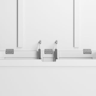 Close-up of the Child Craft Harmony 33" Kids Toy Box in matte white, showing a white cabinet door with two metal hinges and hydraulic support arms for smooth opening and closing. Both the toy box and background are white.