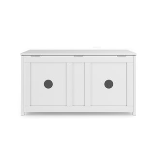 The Child Craft Harmony 33" Kids Toy Box in matte white features a wooden storage bench with a hinged top and two sliding doors, each with a circular cutout handle in the center.