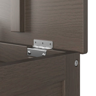 A close-up of a metal hinge fastened with screws joins the vertical and horizontal panels inside the Harmony 33" Kids Toy Box by Child Craft in Dapper Gray.