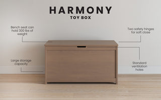 The Child Craft Harmony 33" Kids Toy Box in Dusty Heather is shown against a wall. It features a 300 lbs bench seat, spacious storage, two safety hinges for soft closure, and standard ventilation holes.