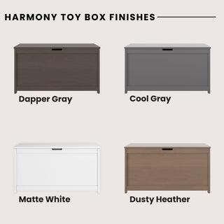 Four Child Craft Harmony 33" Kids Toy Boxes are shown in dapper gray (dark wood), cool gray (solid gray), matte white, and dusty heather (light brown wood), each clearly labeled with its finish name.