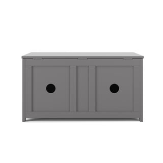 The Child Craft Harmony 33" Kids Toy Box in Cool Gray features a hinged lid and two sliding doors, each with a round cut-out center handle, combining storage and seating in stylish wooden design.