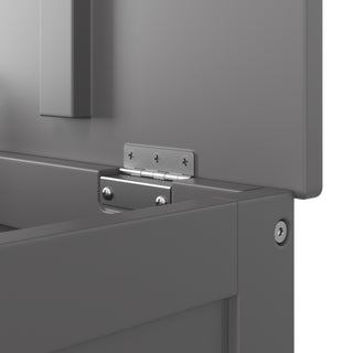 Close-up of a metal hinge with visible screws on the Harmony 33" Kids Toy Box in Cool Gray by Child Craft, highlighting where two panels meet at the corner.