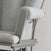 Close-up of the Child Craft Tranquil Nursery Glider Cushion in gray, featuring a wooden frame and built-in side pocket on the armrest. Its soft, plush upholstery offers a cozy, comfortable experience as a baby rocking chair.