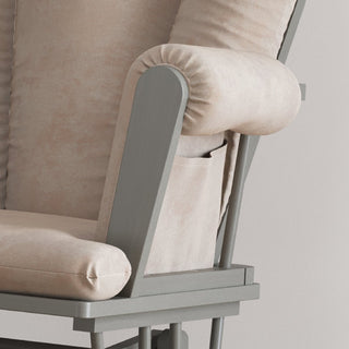 Close-up of the Child Craft Tranquil Nursery Glider Cushion, a beige, cushioned chair with a wooden frame. It features a built-in side pocket and plush seat and backrest—ideal for relaxing with your baby.