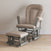 The Child Craft Tranquil Nursery Glider Cushion and matching ottoman, with gray wooden frames and visible gliding mechanisms, create a cozy baby rocking chair set for your nursery’s light wood floor and off-white wall.