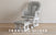 A matte white Child Craft Tranquil Nursery Glider and Ottoman with gray herringbone upholstery sits on a light wood floor against a beige wall. Text reads: TRANQUIL NURSERY GLIDER AND OTTOMAN, MATTE WHITE / GRAY HERRINGBONE.