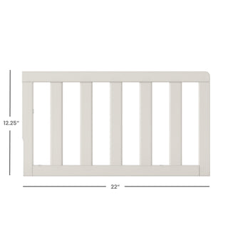 The Child Craft F09501 Toddler Guard Rail in Brushed Cotton features white wood, vertical slats, and measures 12.25" high by 22" wide—perfect for crib conversion. Shown on a white background with labeled measurements.