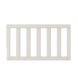The Child Craft F09501 Toddler Guard Rail in Brushed Cotton is a white wooden bed rail with vertical slats and smooth edges, designed for compatibility with Child Craft cribs and shown against a plain white background.