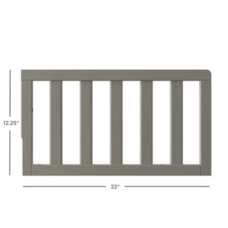 The Child Craft F09501 Toddler Guard Rail in Lunar Gray features strong wood construction, vertical slats, and measures 12.25"H x 22"W—offering a simple, safe design ideal for crib-to-toddler bed conversions.