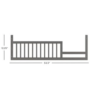 The Child Craft F09503 Toddler Guard Rail in Midnight Gray measures 54.5" x 12.25", features left-side vertical slats, and has mounting holes on each end for secure attachment to a crib or bed as part of a conversion kit.
