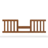 The Child Craft F09514 Toddler Guard Rail in Coach Cherry features vertical slats and an open center, attaching to the side of a crib toddler bed to enhance safety and security.