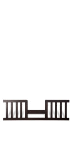 The Child Craft F09514 Toddler Guard Rail in Jamocha features vertical slats and a dark wood finish, providing secure crib-to-toddler bed conversion. Stands upright against a white background; prevents falls for added safety.