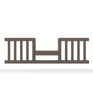 The Child Craft F09514 Toddler Guard Rail in Dapper Grey features vertical slats, an open center with a horizontal support bar, and is designed for easy crib-to-toddler bed conversion while providing added safety for your child.