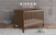 The Child Craft Kieran 3-in-1 Convertible Crib in Toasted Chestnut stands on a rug, showcasing a gentle herringbone pattern, angled corners, two finishes, tapered legs, and converts to a bed. Toys are scattered nearby.