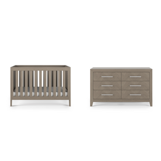 The Child Craft Kieran 3-in-1 Convertible Crib in Crescent Gray is shown beside a matching six-drawer dresser with silver handles, both set against a white background.