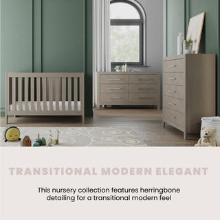 A modern nursery showcases the Child Craft Kieran 3-in-1 Convertible Crib in Crescent Gray, a dresser, and chest against green paneled walls. Toys and a rug accent the space. Text: Transitional Modern Elegant. Features herringbone detailing.