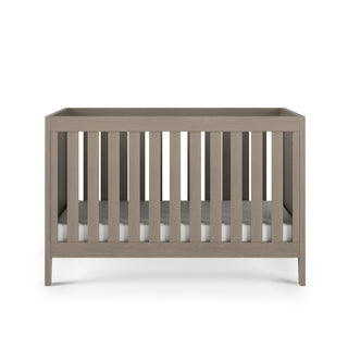 The Child Craft Kieran 3-in-1 Convertible Crib in Crescent Gray comes with a white pillow.
